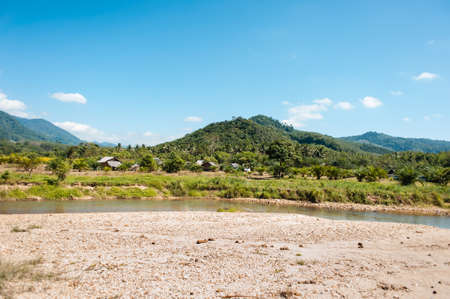 Panoramic view of small river proceeds through hillsの写真素材