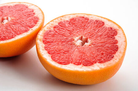 two halves of the tasty grapefruit on a whiteの写真素材