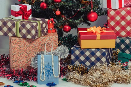 Colorful christmas gift boxes under  fir tree. Christmastime