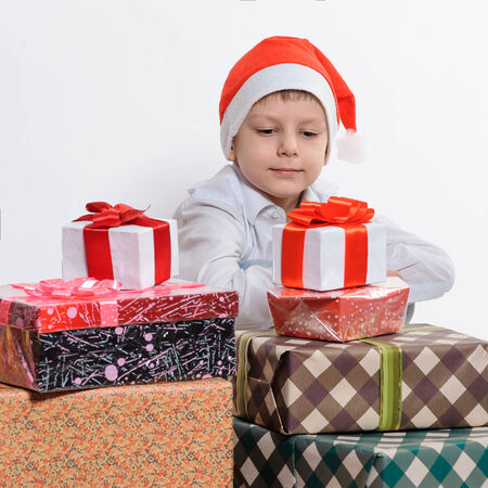 Child in Santa red hat  looking Christmas gifts. Christmas concept.の写真素材