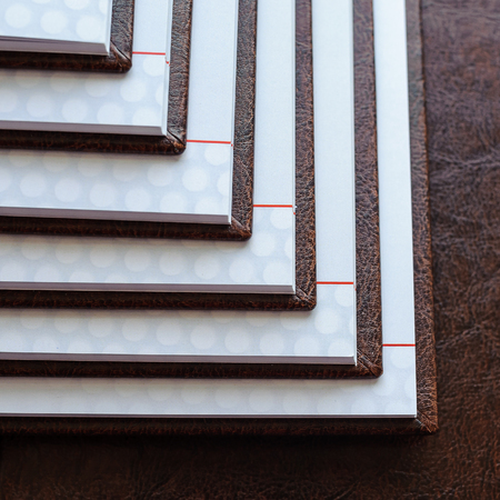 the stack of open books in a brown leather cover, closeupの写真素材