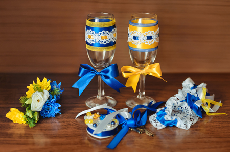 wedding accessories: champagne glasses, a garter for the bride, lock, boutonniere for the groomの写真素材