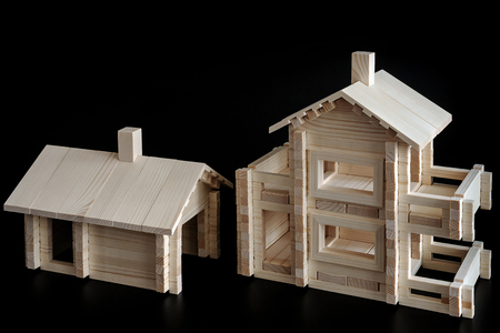 Little wooden house with natural colored toy blocks on black backgroundの写真素材