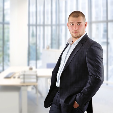 handsome businessman in a dark suit in his officeの写真素材