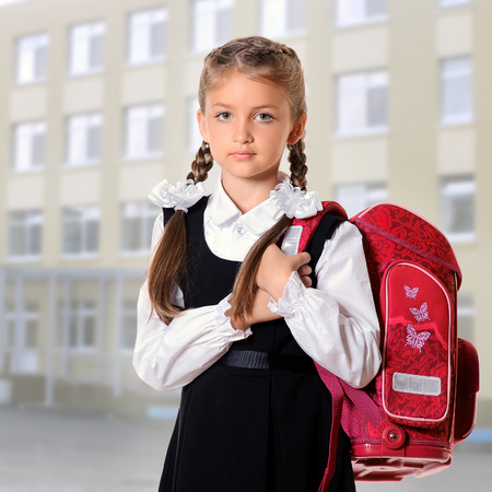 Portrait of schoolgirl with red satchel. Education and school conceptの写真素材