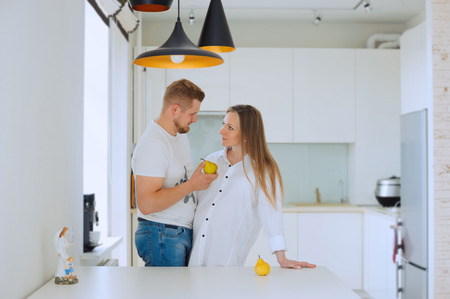 Pregnant woman with husband in the kitchenの写真素材