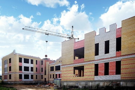 The process of construction of multi-apartment building. Building construction site with craneの写真素材