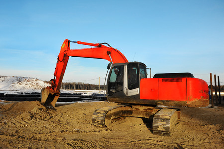 Heavy big red excavator working on new construction siteの写真素材