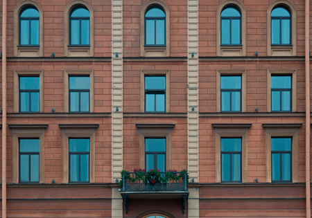 Windows and balcony on facade of urban apartment building. Vintage house facade. Front view. St. Petersburg, Russiaの写真素材