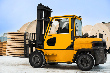 Yellow forklift transports the boards at the industrial area. Woodworking industryの写真素材