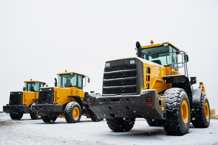 Yellow wheel front loaders. Construction and handling equipment. Heavy diesel tractor, construction...