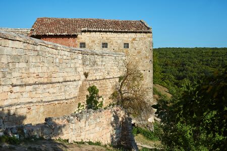 Old abandoned building with a stone wall. Stone house in the mountains. Sunny summer day, clear blue sky.の写真素材