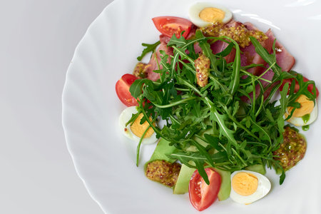 Delicious salad with medium beef, fresh vegetables, arugula and eggsの写真素材