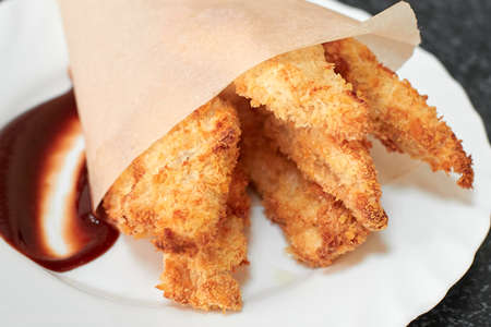 Crispy fried chicken breast strips with sauce