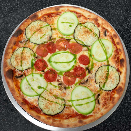 Delicious vegetarian pizza with eggplant, zucchini, tomatoes and mushrooms. Top viewの写真素材