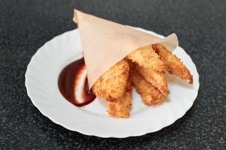 Crispy fried chicken breast strips with sauceの写真素材