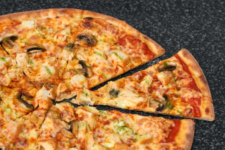 Sliced pizza with chicken, mushrooms and cheeseの写真素材
