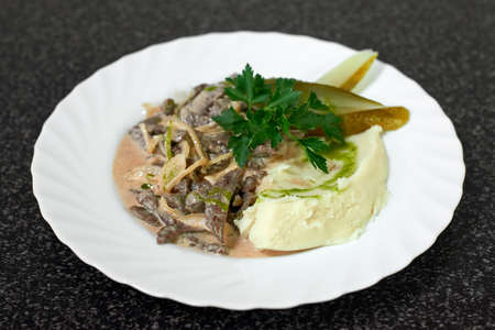 Beef stew in creamy sauce with mashed potatoes and pickles. Beef Stroganoff, traditional Russian dishの写真素材