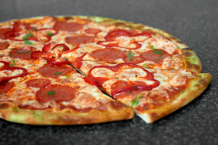 Delicious pizza with salami, red pepper and tomatoesの写真素材