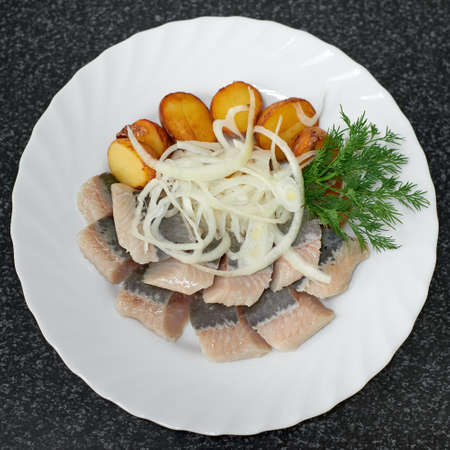 Pieces of salted herring fillet with baked potatoes and onions. Top viewの写真素材