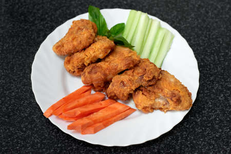 Fried chicken wings in batter and fresh vegetableの写真素材