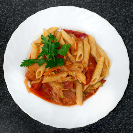Penne pasta cooked with stewed vegetables and herbs. Top viewの写真素材