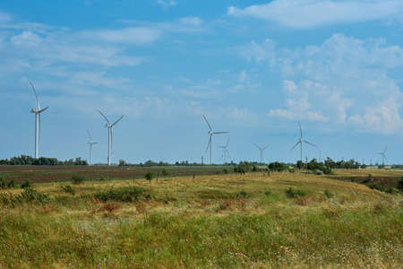 Panoramic view of wind farm with high wind turbines for generation electricity. Green energy concept. Windmills for electric power production. Energy production with clean and renewable energyの写真素材