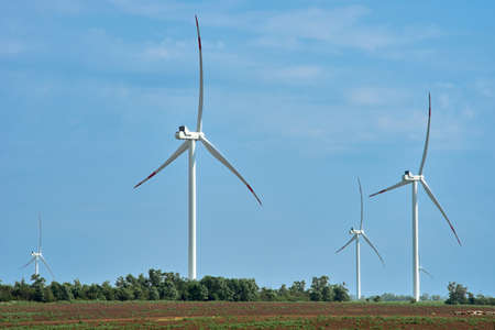 Wind farm with high wind turbines for generation electricity. Windmill park alternative energy. Windmills for electric power production. Energy production with clean and renewable energyの写真素材