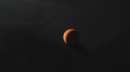 A bright orange sphere sits prominently on a dark, textured surface. The soft lighting creates a contrast, emphasizing the sphere's smooth surfaces and highlighting the intricate patterns beneath.の素材