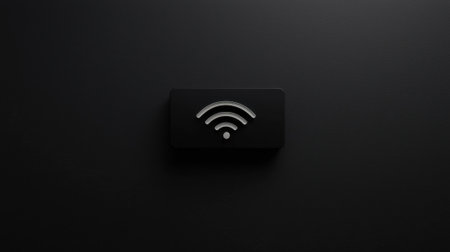 A black and silver wifi symbol is displayed on a black background. The wifi symbol is a small square with a curved line on top and a circle on the bottom. Concept of technology and connectivityの素材