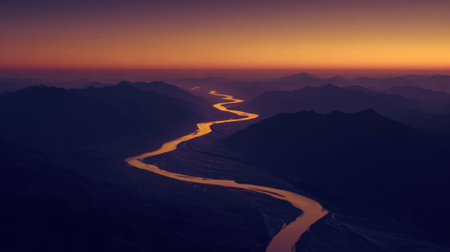 Orange and purple hues fill the sky as the river curves through the mountains at dusk.の素材