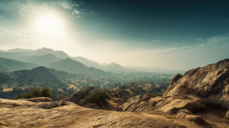 Vast mountain ranges stretch into the horizon with rocky outcrops in the foreground. The sun shines brightly above illuminating the lush valleys below. The scene captures a serene moment in nature.の素材