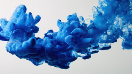 Bright blue ink dances and swirls in water creating beautiful abstract patterns and designs.の素材