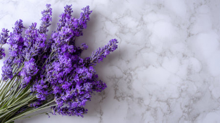 Vibrant lavender blossoms are arranged gracefully on a sleek marble surface creating a tranquil scene.の素材