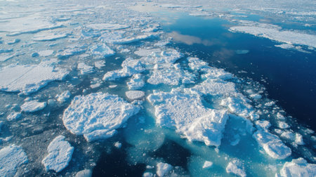 A serene view of icebergs scattered across the blue ocean, reflecting sunlight. The image captures a lush, untouched Arctic landscape during summer, emphasizing the beauty of nature.の素材