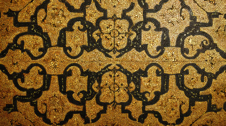 Detailed golden mosaic features elaborate floral and geometric designs on a textured surface, highlighting artistic craftsmanship from a historic period.の素材