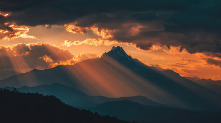 Vibrant colors fill the sky as sunlight beams down on the mountain range at dusk.の素材