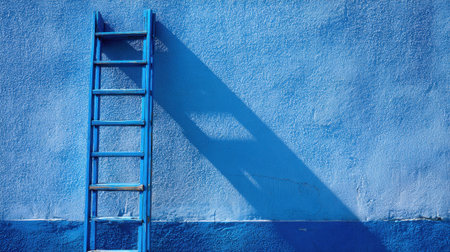A wooden ladder leans against a vibrant blue wall creating striking shadows in sunlight.の素材