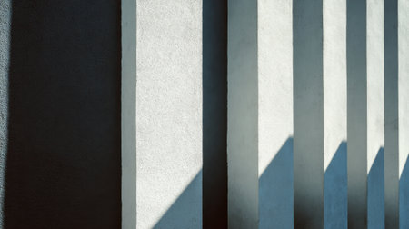 Bright sunlight creates striking shadows on the surface of intriguing wall structures.の素材
