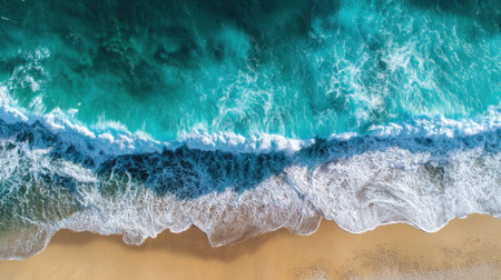 The ocean is calm and the waves are small. The water is a beautiful shade of blue. The beach is empty and peacefulの素材