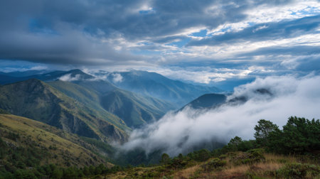 Peaceful view of a mountain range at dawn, where mist hugs the valleys and peaks. Soft clouds drift among the hills, creating a serene atmosphere for nature lovers.の素材