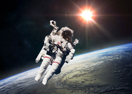 Astronaut in outer space against the backdrop of the planet earth. 