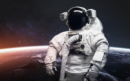 Astronaut at the spacewalk. Awesome beautiful Earth planet in cold and warm light.