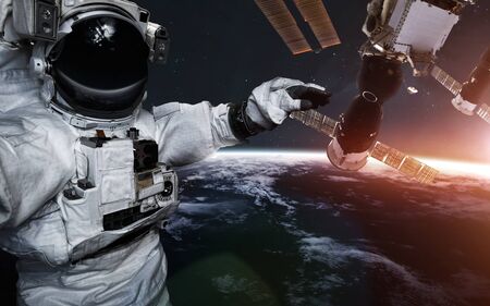 Astronaut at spacewalk against international space station. Science fiction art.