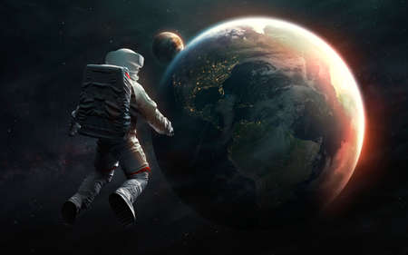 Astronaut at spacewalk looks at Earth planet.の写真素材