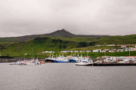 View of the port town located at the foot of Icelandic green hillsの写真素材