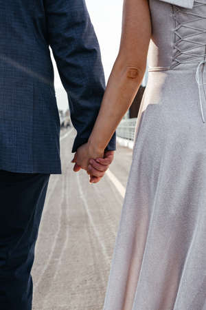 cropped view of african american couple holding hands on bridgeの写真素材