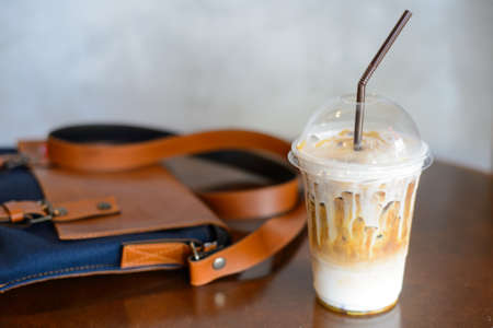 Coffee in plastic cups and leather bagの写真素材