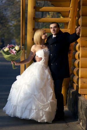 Beautiful wedding couple hold each other hand and embracing in autumn park under the sunbeam, wooden sunny background.A young couple in love. の写真素材