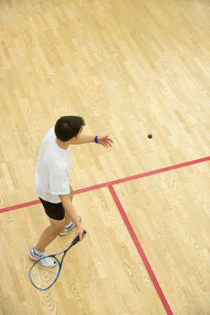 Squash player in action on squash court, back view./Two men playing match of squash.の写真素材
